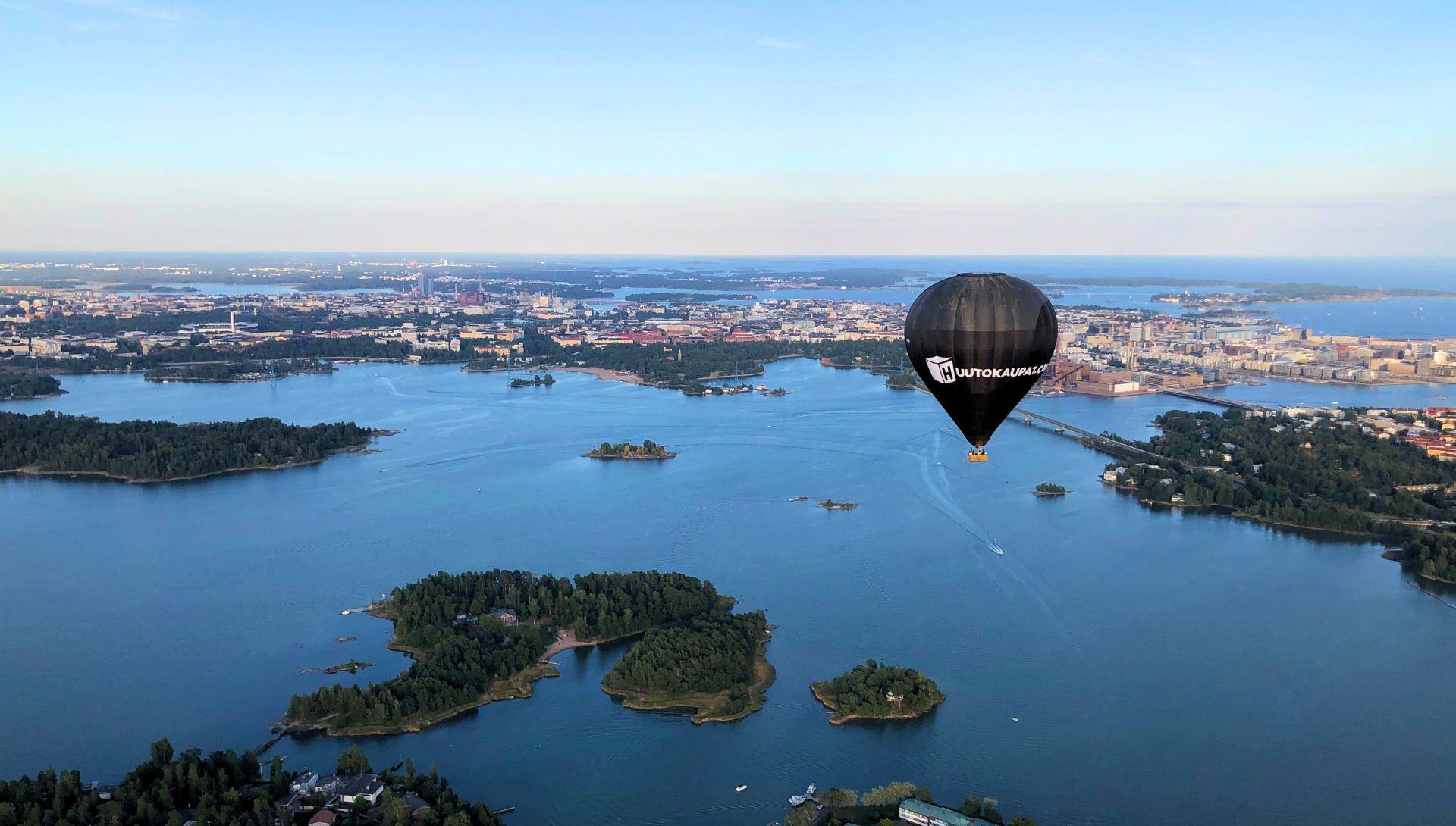 Huutokaupat.com -kuumailmapallo lentää Helsingin yllä.